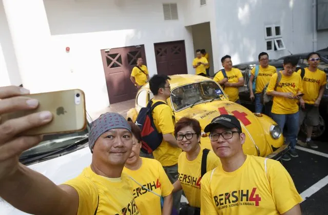 Supporters of pro-democracy group “Bersih” (Clean) take selfie photos with a recently vandalised Volkswagen Beetle used to promote the rally, at the Kuala Lumpur and Selangor Chinese Assembly Hall, ahead of their march in Malaysia's capital city of Kuala Lumpur August 29, 2015. (Photo by Edgar Su/Reuters)