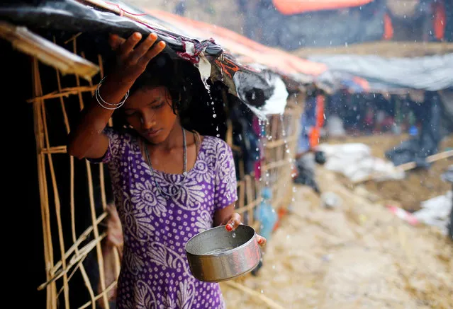 A Rohingya refugee girl collects rain water at a makeshift camp in Cox's Bazar, Bangladesh, September 17, 2017. (Photo by Mohammad Ponir Hossain/Reuters)