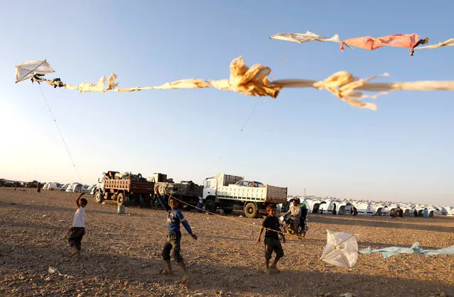 Children fly their kites as they play inside a refugee camp for people displaced by fightings between the Syrian Democratic Forces and Islamic State militants in Ain Issa, Syria October 3, 2017. (Photo by Erik De Castro/Reuters)