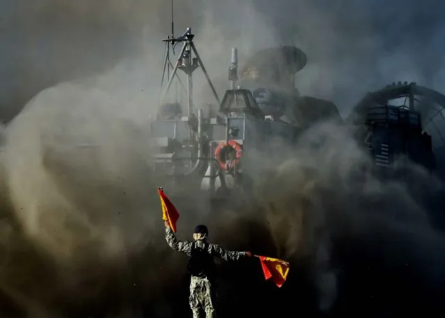 A signalman directs a US Marines Landing Craft Air Cushion (LCAC) hovercraft during an amphibious landing operation with the Japan Maritime Self-Defense Force (JMSDF) at the Dawn Blitz 2015 exercise in Camp Pendleton, California on September 5, 2015. Japan's defense ministry has made its biggest ever budget request, as Tokyo bolsters its military amid lingering territorial rows and worries over China's expanding naval reach. (Photo by Mark Ralston/AFP Photo)