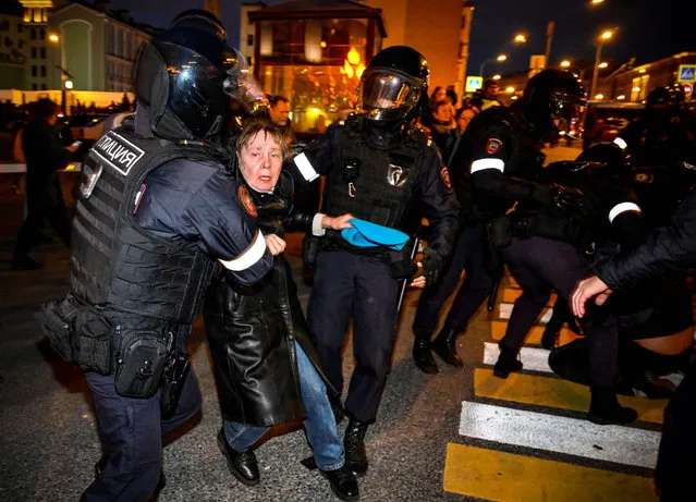 Police officers detain a woman following calls to protest against partial mobilisation announced by Russian President, in Moscow, on September 21, 2022. (Photo by Alexander Nemenov/AFP Photo)