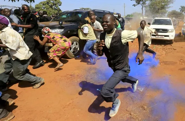 Supporters of Uganda's former Prime Minister Amama Mbabazi run from coloured tear gas canister police used to disperse a gathering in Jinja town in eastern Uganda September 10, 2015. (Photo by James Akena/Reuters)