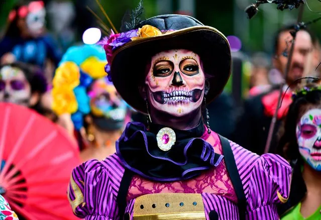 People disguised as “Catrina” (Mexican representation of death) take part in the “Catrinas Parade” along Reforma Avenue, in Mexico City on October 22, 2017. (Photo by Ronaldo Schemidt/AFP Photo)