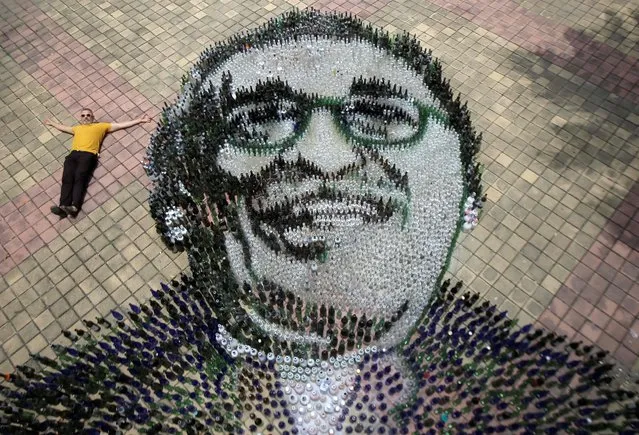 Aerial view showing artist Eduardo Butron posing with recycled glass bottles forming the image of Colombian writer Gabriel Garcia Marquez (1927-2014), at Plaza de Banderas in Turbaco, department of Bolivar, Colombia, on September 2, 2022. (Photo by Rafael Quiroz/AFP Photo)