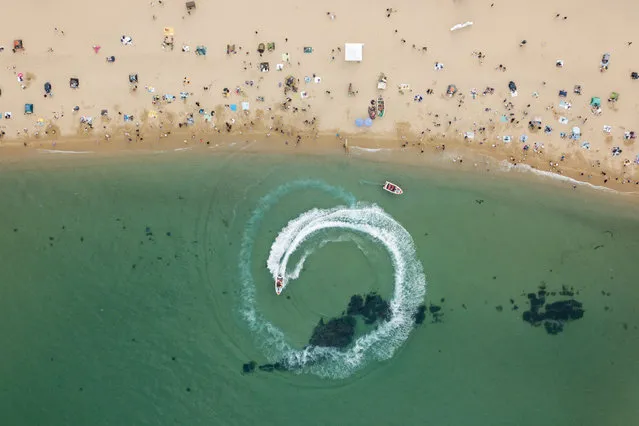 In an aerial photo taken on May 2, 2020 holiday-makers visit a beach in Sokcho, on South Korea's north-east coast during a public holiday long weekend. (Photo by Ed Jones/AFP Photo)
