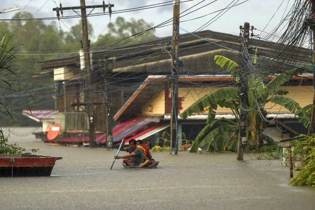 Residents paddle through floodwaters in Ubon Ratchathani province, northeastern Thailand, Monday, October 3, 2022. Heavy rainfall in northern, northeastern and central Thailand on Monday fueled severe flooding, as some areas were further threatened as the authorities had to order pressure on filled to capacity dams eased by releasing water into already overflowing rivers. (Photo by Nava Sangthong/AP Photo)