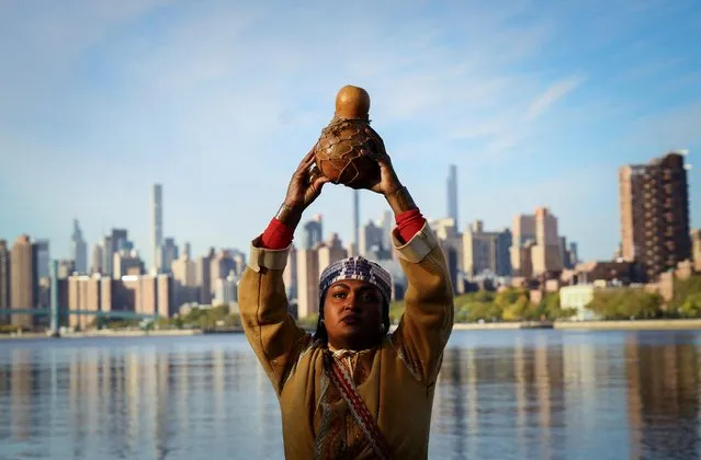 Chenae Bullock of The Shinnecock Indian Nation holds a traditional container of water during an indigenous sunrise water ceremony on the shore of the East River on Randall's Island as Indigenous Peoples' Day is observed in the U.S., in New York City, New York, U.S., October 10, 2022. (Photo by Mike Segar/Reuters)