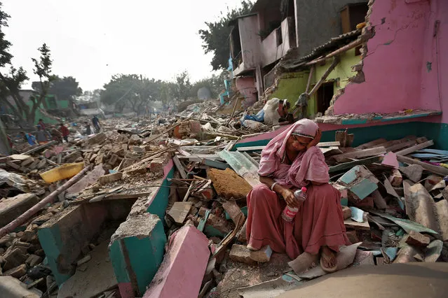 A woman reacts amid the rubble of her home in a slum which was razed to the ground by local authorities in a bid to relocate the residents, Delhi, India, November 2, 2017. (Photo by Cathal McNaughton/Reuters)