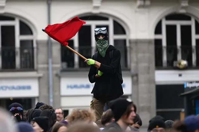 A man waves a flag during a demonstration in Rennes, western France on October 18, 2022 after the CGT and FO trade unions called for a nationwide strike calling for higher salaries, and against the government's requisitioning of fuel refineries to force some strikers back into opening fuel depots. France was preparing for a day of major disruptions on October 18, 2022, after unions called a nationwide transport strike as they remain in deadlock with the government over walkouts at oil depots that have sparked fuel shortages. The move comes after workers at several refineries and depots operated by energy giant TotalEnergies voted to extend their strike action. (Photo by Damien Meyer/AFP Photo)