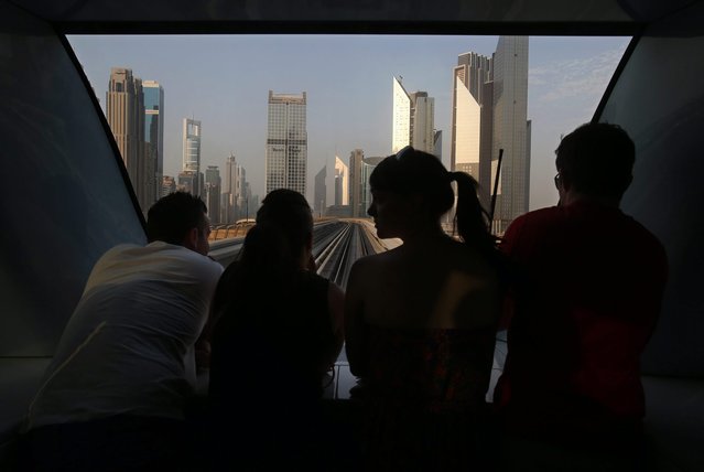 In this September 17, 2014, photo, passengers look at the Sheikh Zayed highway towers from the front window of a remote control metro during afternoon rush hour in Dubai, United Arab Emirates. The 5-year-old Dubai metro has grown from serving 60,000 passengers daily in 2009 to 500,000 commuters. (Photo by Kamran Jebreili/AP Photo)