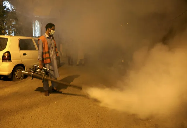 Pakistani health workers fumigate to kill mosquitos in an effort to prevent an outbreak of dengue fever, in Peshawar, Pakistan. Friday, September 23, 2022.  Pakistan has deployed thousands of additional doctors and paramedics in the country's worst flood-hit province to contain the spread of diseases that have killed over 300 people among the flood victims, officials said Friday. (Photo by Muhammad Sajjad/AP Photo)