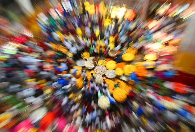 A picture taken with a slow exposure and a zoom effect shows Indian visitors buy flower at a flower market on the eve of Hindu elephant-headed god Lord Ganesh Chaturthi festival in Bangalore, India, 16 September 2015. The ten-day long Hindu festival is celebrated as the birthday of Lord Ganesh and starts on 17 September. (Photo by Jagadeesh N.V./EPA)