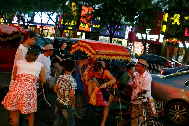 People get off a rickshaw in a restaurant street in Beijing, China, August 25, 2016. (Photo by Thomas Peter/Reuters)