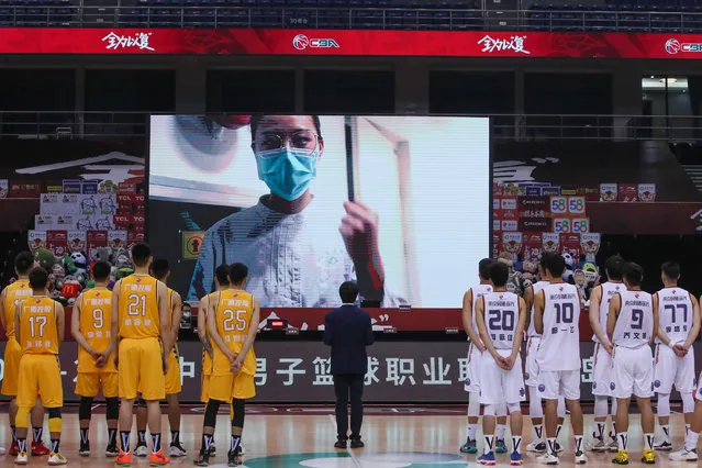 Players pay a silent tribute to martyrs, who died fighting COVID-19, and compatriots, who lost their lives in the epidemic, prior to 2019/2020 Chinese Basketball Association (CBA) League match between Nanjing Monkey Kings and Zhejiang Lions at Guoxin Gymnasium on June 20, 2020 in Qingdao, Shandong Province of China. (Photo by VCG/VCG via Getty Images)