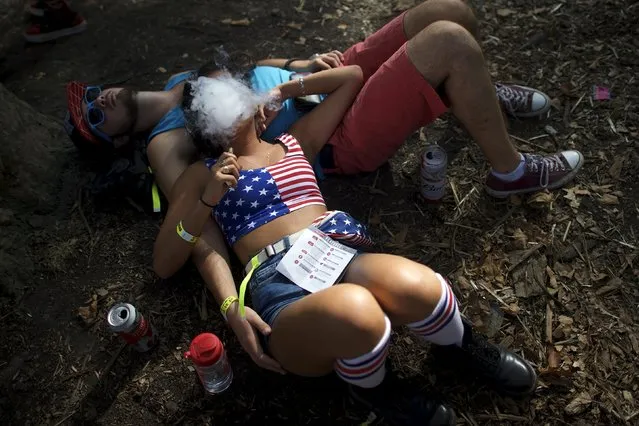 A couple lies down and smokes during the fourth annual Made in America Music Festival in Philadelphia, Pennsylvania September 5, 2015. (Photo by Mark Makela/Reuters)