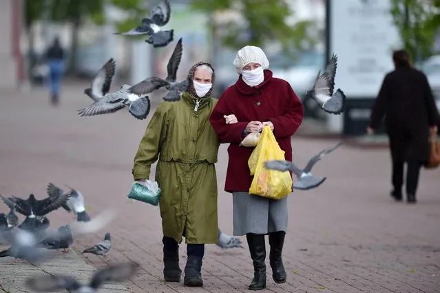 Two women wearing face masks walk down a street in the town of Vitebsk, some 295 km northeast of Minsk, on May 21, 2020. 33 371 COVID-19 cases and 185 deaths were registered in Belarus, according to authorities. (Photo by Sergei Gapon/AFP Photo)