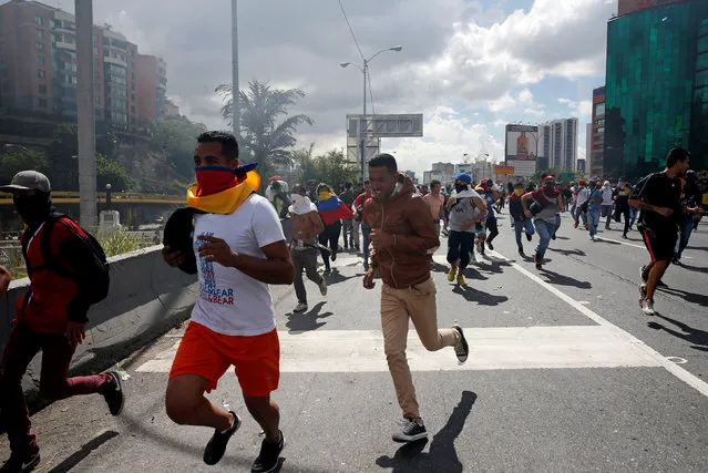 Protesters run after clashes with the police during a rally to demand a referendum to remove Venezuela's President Nicolas Maduro in Caracas, Venezuela, September 1, 2016. (Photo by Carlos Garcia Rawlins/Reuters)