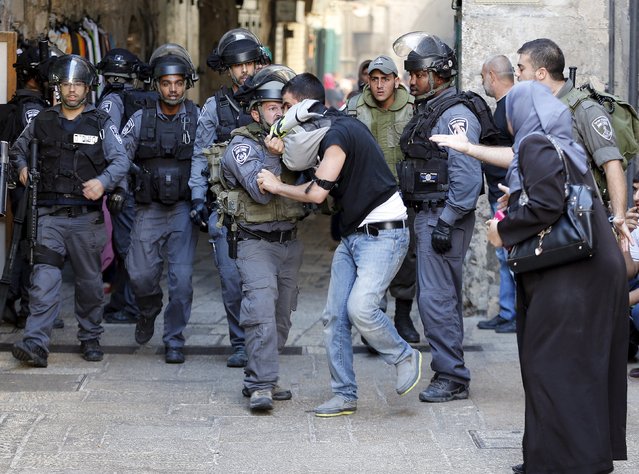 An Israeli policeman prevents a Palestinian man from entering the compound which houses al-Aqsa mosque, known by Muslims as the Noble Sanctuary and by Jews as the Temple Mount, in Jerusalem's Old City September 28, 2015. (Photo by Ammar Awad/Reuters)