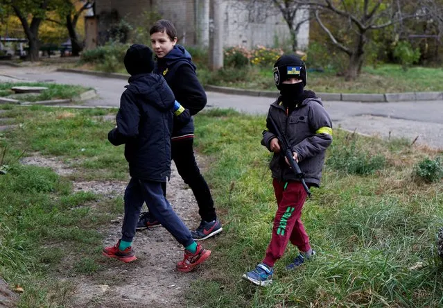 Danilo, a six-year-old Ukrainian boy, holds a toy machine gun as he strolls with his friend around their neighbourhood in Kherson, Ukraine on November 16, 2022. (Photo by Murad Sezer/Reuters)