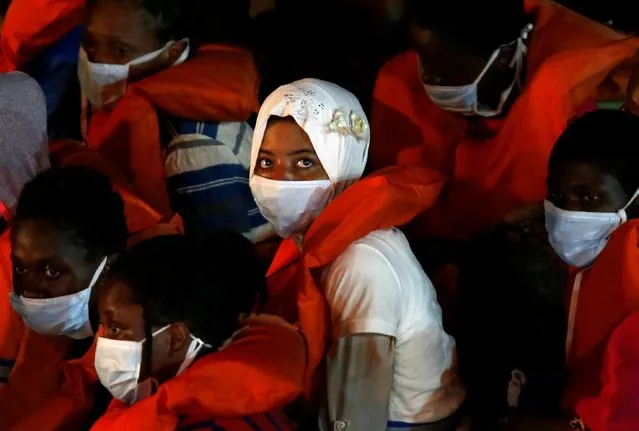 Rescued migrants look on from onboard an Armed Forces of Malta vessel upon their arrival in Senglea, in Valletta's Grand Harbour, as the coronavirus disease (COVID-19) outbreak continues in Malta on August 3, 2020. (Photo by Darrin Zammit Lupi/Reuters)