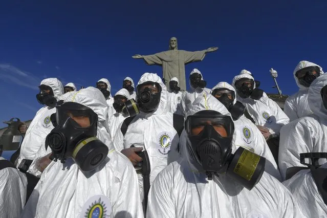 Soldiers of the Brazilian Armed Forces are seen during the disinfection procedures of the Christ The Redeemer statue at the Corcovado mountain prior to the opening of the touristic attraction on August 15, in Rio de Janeiro, Brazil, on August 13, 2020, amid the COVID-19 novel coronavirus pandemic. (Photo by Mauro Pimentel/AFP Photo)
