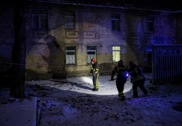 Rescuers work at the site of a building destroyed by a Russian drone attack, as their attack on Ukraine continues, in Kyiv, Ukraine on December 14, 2022. (Photo by Gleb Garanich/Reuters)