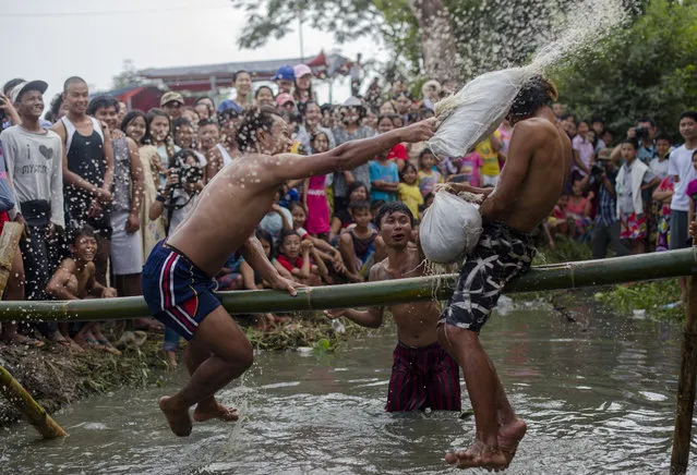 Youths play a traditional pillow fight game on a bamboo pole during festivities marking Myanmar's 70th Independence Day on the outskirts of Yangon on January 4, 2018. The country is celebrating the 70th anniversary of its declaration of independence from British colonial rule. (Photo by Ye Aung Thu/AFP Photo)