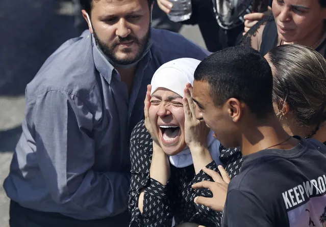 The wife of Rami Kaaki, one of ten firefighters who were killed during the last week's explosion that hit the seaport of Beirut, mourns during her husband's funeral at the firefighter headquarters, in Beirut, Lebanon, Tuesday, August 11, 2020. (Photo by Hussein Malla/AP Photo)