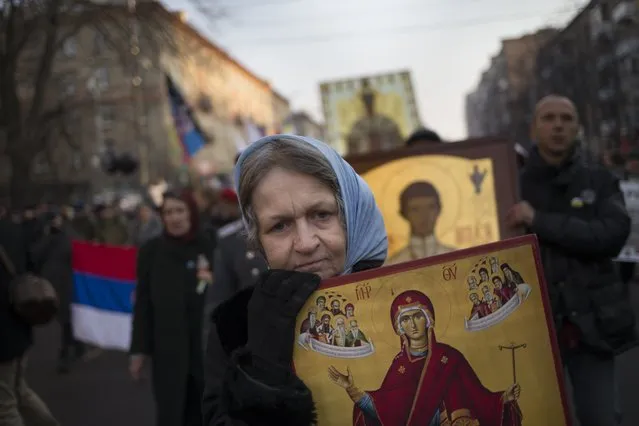 Russian nationalists carry Orthodox icons during a march in support of pro-Russian separatists fighting with Ukrainian government forces in eastern Ukraine in Moscow to mark People's Unity Day, a public holiday in Russia, on Tuesday, November 4, 2014. (Photo by Alexander Zemlianichenko/AP Photo)