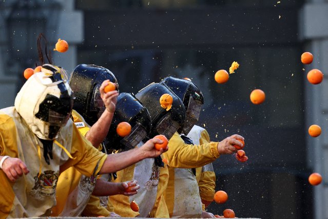 Revellers take part in a fight with oranges during an annual carnival battle in Ivrea, Italy, on February 11, 2024. (Photo by Guglielmo Mangiapane/Reuters)