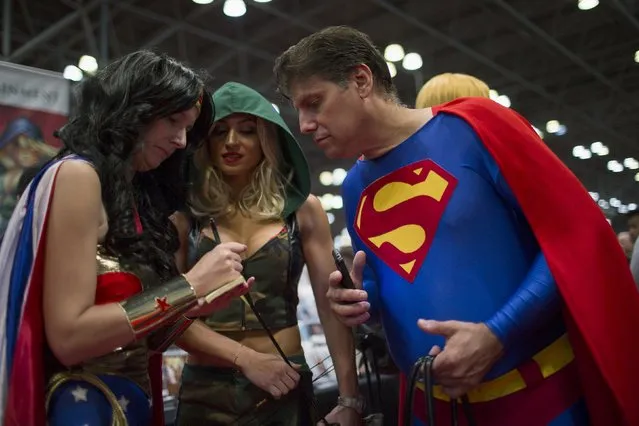 New York Comic Con attendees share information during Day Three of the event in Manhattan, New York, October 10, 2015. The event draws thousands of costumed fans, panels of pop culture luminaries and features a sprawling floor of vendors in a space equivalent to more than three football fields at the Jacob Javits Convention Center on Manhattan's West side. (Photo by Eduardo Munoz/Reuters)