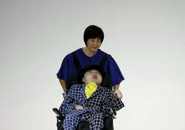 A model, who is a mucopolysaccharidosis patient, is pushed by his mother in a wheelchair as he presents a creation by designer Takafumi Tsuruta from his Spring/Summer 2016 collection for his brand tenbo during Tokyo Fashion Week in Tokyo, Japan, October 13, 2015. (Photo by Yuya Shino/Reuters)