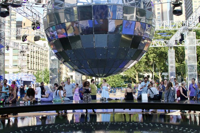 New Yorkers relax under a giant disco ball on July 18, 2025 in New York City. (Photo by ZUMAPRESS.com/The Mega Agency)