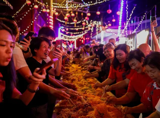 Villagers prepare to toss yusheng or raw fish during a “Lo Hei” (“tossing up good fortune”) ceremony during the Lunar New Year's Eve celebration in Karak, Pahang, Malaysia on January 21, 2023. (Photo by Hasnoor Hussain/Reuters)