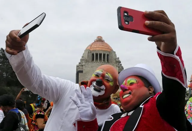 Clonwns take a selfie with cell phones at the Monument to the Revolution during the Latin American Clown Convention in Mexico City, Mexico, October 21, 2015. (Photo by Henry Romero/Reuters)