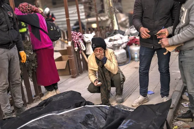A family mourns next to bodies of relatives that were pulled from the rubble of a destroyed building in Antakya, southeastern Turkey, Wednesday, February 15, 2023. (Photo by Bernat Armangue/AP Photo)