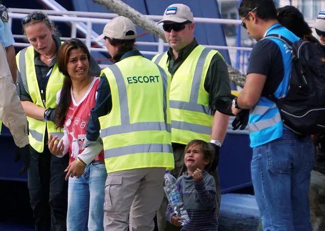 A migrant woman and child cry  as they are forced to board a Turkish vessel in the port of Mytilene on the island of Lesbos on October 5, 2016 to be deported back to Turkey. The Greek authorities returned from the island of Lesbos to Dikili in Turkey a group of 55 asylum seekers, mostly Pakistanis and Algerians, as part of the EU-Turkey agreement. Among this group are the first 37 failed asylum seekers. Besides 20 Pakistanis, 20 Algerians, this group includes five Moroccans, four Afghans, three Bangladeshis, one Sri Lankan, an Iranian and a Palestinian. (Photo by AFP Photo/Stringer)