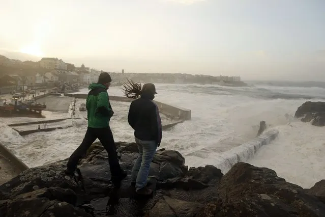 People watch waves crash against the harbour wall at Portstewart in northern Ireland December 10, 2014. Up to 17,000 residents in the west of Scotland were left without power on Wednesday morning as a “weather bomb” of wet and windy conditions battered parts of Britain with gusts expected to reach up to 80 miles per hour (130 km/h). (Photo by Cathal McNaughton/Reuters)
