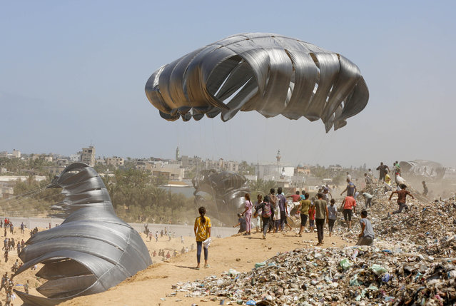Humanitarian aid packages descending with parachutes over Deir al-Balah amid the ongoing Israeli strikes in Gaza on August 22, 2025. Attempts to drop humanitarian aid supplies by parachute from the air continue in the Gaza Strip, which is under attack and embargo by Israel. Planes dropped aid by parachute from the air to the city of Deir al-Balah, located in the central part of the Gaza Strip. Palestinians gathered in large numbers in the area to receive aid. (Photo by Mohammed Nassar/Anadolu via Getty Images)