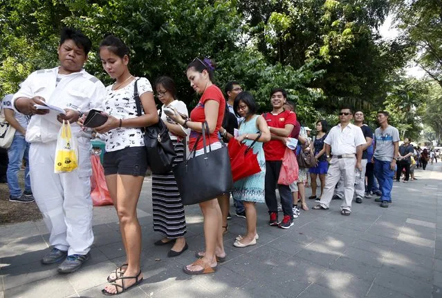 Myanmar nationals queue to cast their votes outside the Myanmar embassy in Singapore, October 15, 2015. Hundreds of voters queue up from as early as 5am outside the embassy to cast their votes for the general elections on November 8, according to volunteers. About 20000 Myanmar nationals submitted their requests for early voting according to local media. (Photo by Edgar Su/Reuters)