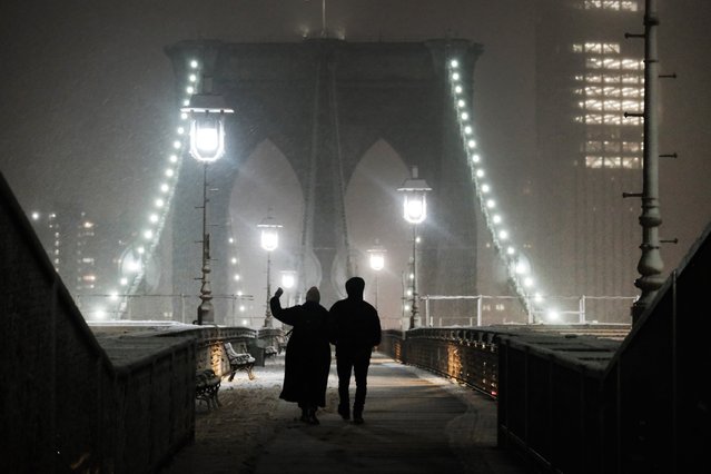 People walk across the Brooklyn Bridge during a storm on February 27, 2023 in New York City. Parts of northern New York City could see up to five inches of snow by morning in what would be the first real snowfall of the winter. (Photo by Spencer Platt/Getty Images)
