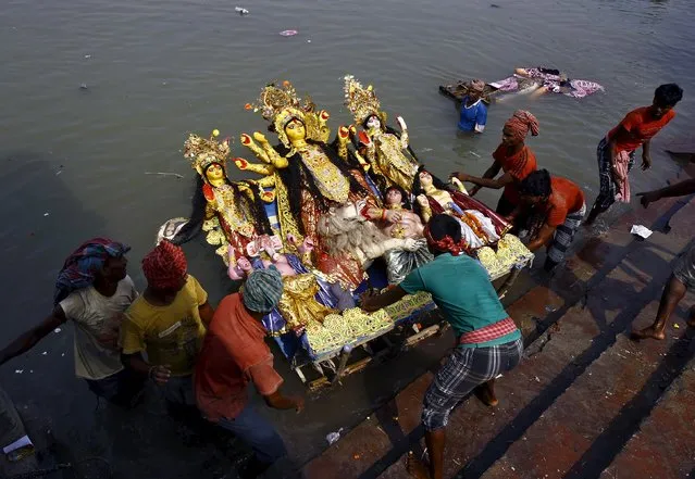 Devotees immerse an idol of the Hindu goddess Durga into the Ganges river after end of the Durga Puja festival in Kolkata, India, October 25, 2015. (Photo by Rupak De Chowdhuri/Reuters)