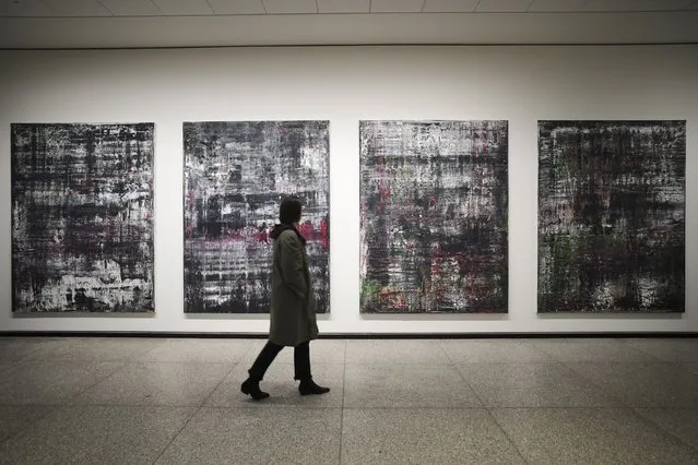 A woman walks in front of the “Birkenau” paintings in a new exhibition with art works of German artist Gerhard Richter at the New National Gallery in Berlin, Germany, Friday, March 31, 2023. Richter's foundation gave on permanent loan 100 works of the artist to the New National Gallery where they will be shown in the permanent exhibition. (Photo by Markus Schreiber/AP Photo)