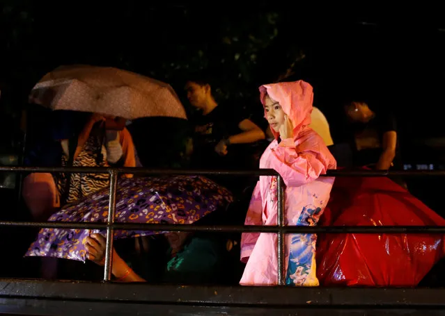 Residents who evacuated their homes due to Typhoon Haima ride on a government truck as they are transported to an evacuation centre  in San Fernando, la Union in northern Philippines, October 19, 2016. (Photo by Erik De Castro/Reuters)