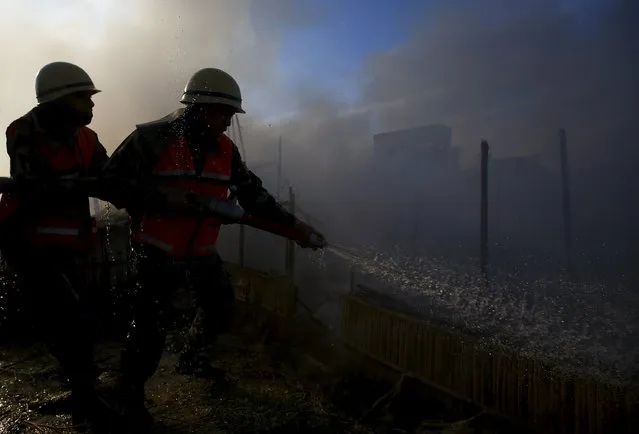 Firefighters try to douse a fire at a poultry farm in Bhaktapur April 14, 2015. (Photo by Navesh Chitrakar/Reuters)