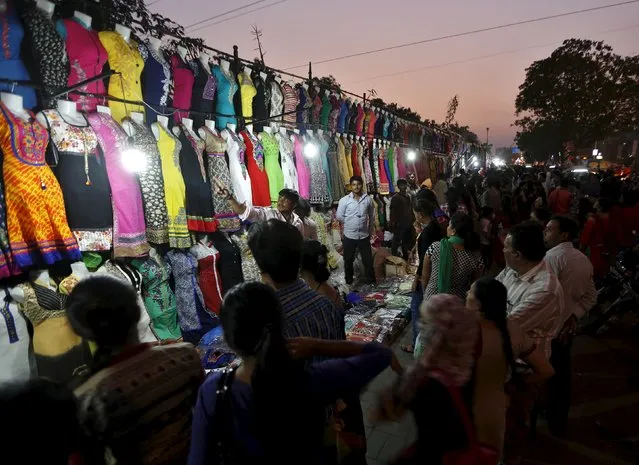 People buy dresses at a roadside market place ahead of the Hindu festival of Diwali in Ahmedabad, India, November 8, 2015. Diwali, the annual festival of lights will be observed this year on November 11. (Photo by Amit Dave/Reuters)