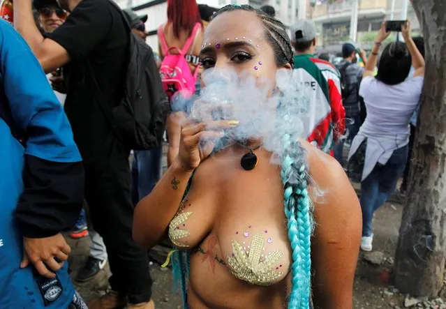 A woman smokes marijuana during a Global March for Marijuana in Medellin, Colombia, May 5, 2018. (Photo by Fredy Builes/Reuters)