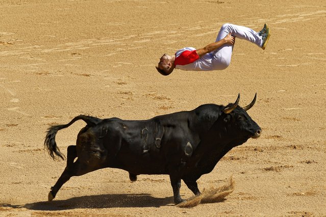 A '“Recortador'” jumps over a bull in the bull ring during the Recortadores festival at the San Fermin fiestas in Pamplona, northern Spain, Sunday, July 7, 2024. (Photo by Alvaro Barrientos/AP Photo)