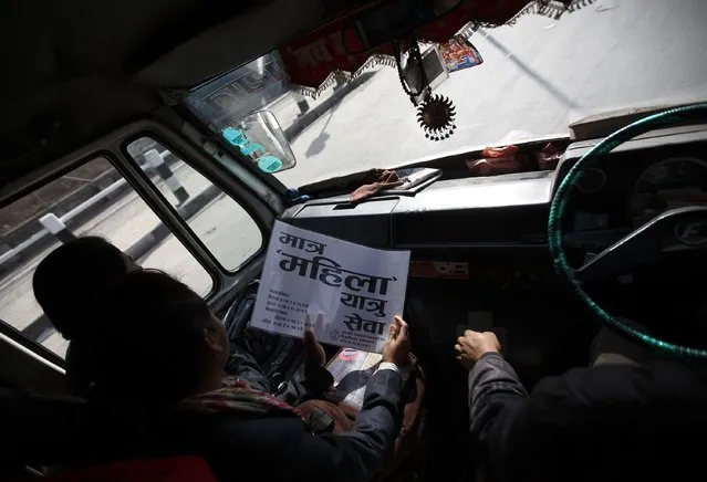 A passenger holds a placard that reads “women-only bus service” as she travels in a women-only bus in Kathmandu January 6, 2015. (Photo by Navesh Chitrakar/Reuters)