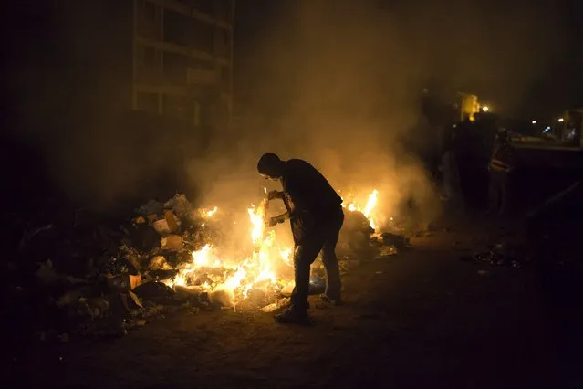A man burns rubbish on the side of a road in Dandora, Nairobi, Kenya, June 14, 2015. (Photo by Siegfried Modola/Reuters)